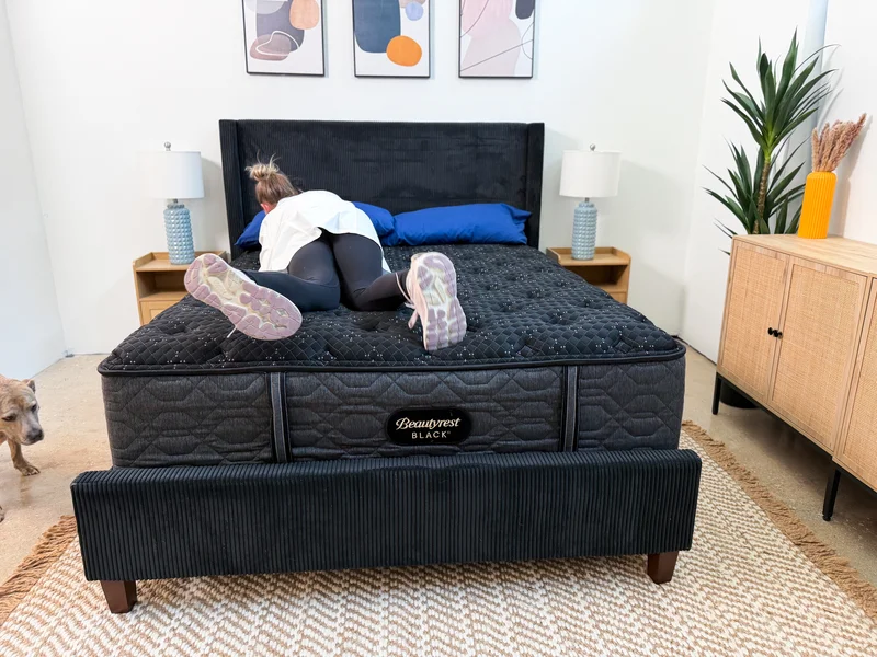 Mattress tester rolls on Beautyrest Black bed.