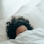 unrecognizable person sleeping under blanket 4546117