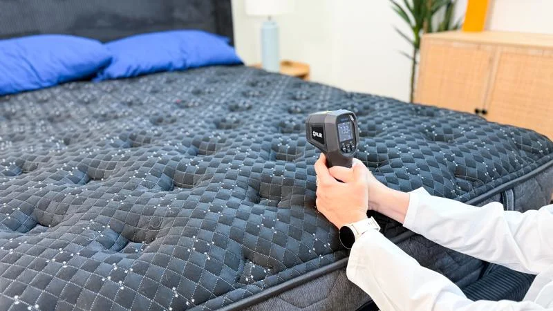 Our product tester takes thermal readings of the Beautyrest Black mattress.