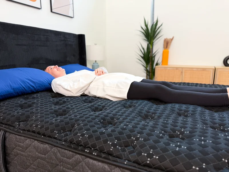 Person sleeping on their back in the middle of the Beautyrest Black bed.