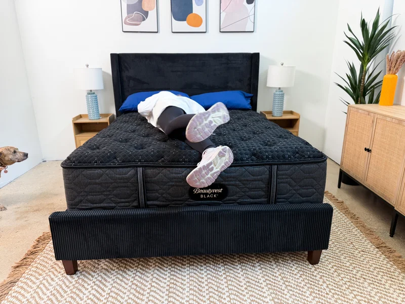 Mattress tester rolls on Beautyrest Black bed.