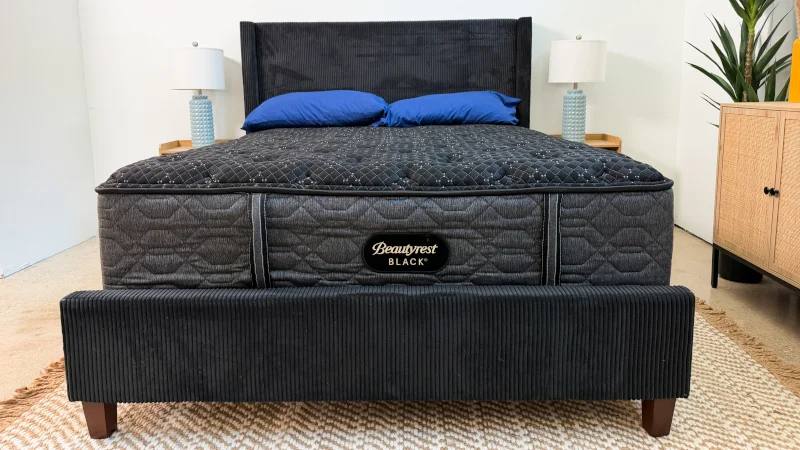 Beautyrest Black bed with blue pillows and black headboard and footboard.