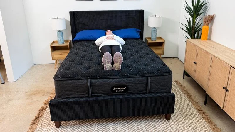 Person sleeping on their back in the middle of the Beautyrest Black bed.