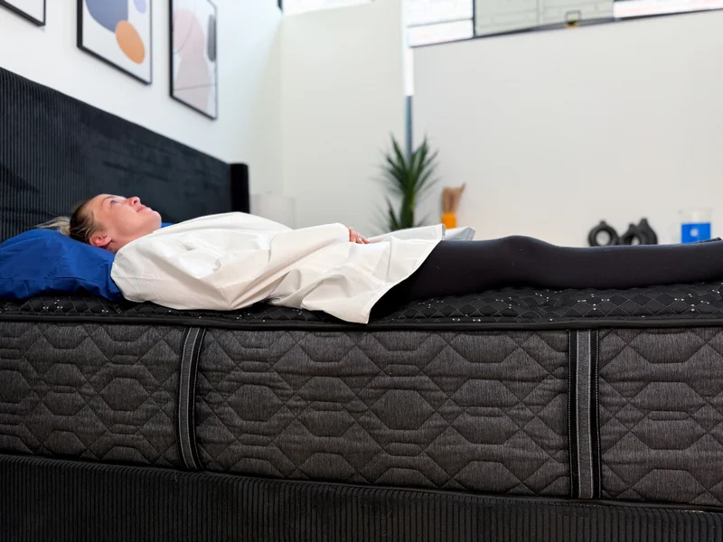 Tester evaluating the edge support of the Beautyrest Black while lying down.