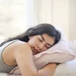 woman in gray tank top lying on bed 3807760 1