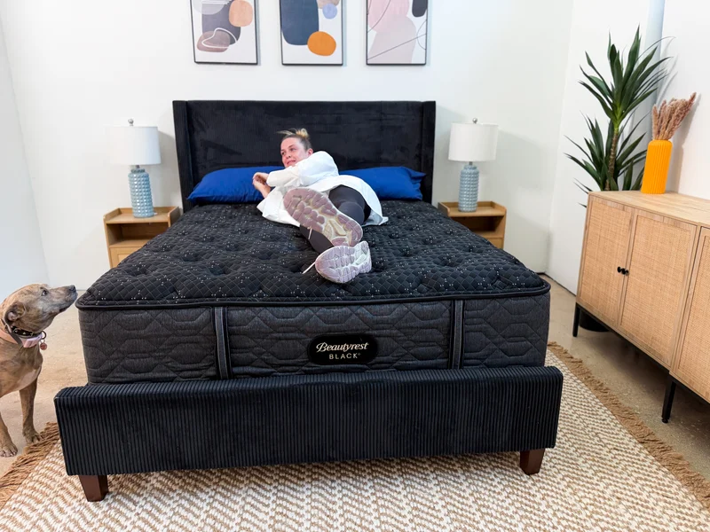 Mattress tester rolls on Beautyrest Black bed.