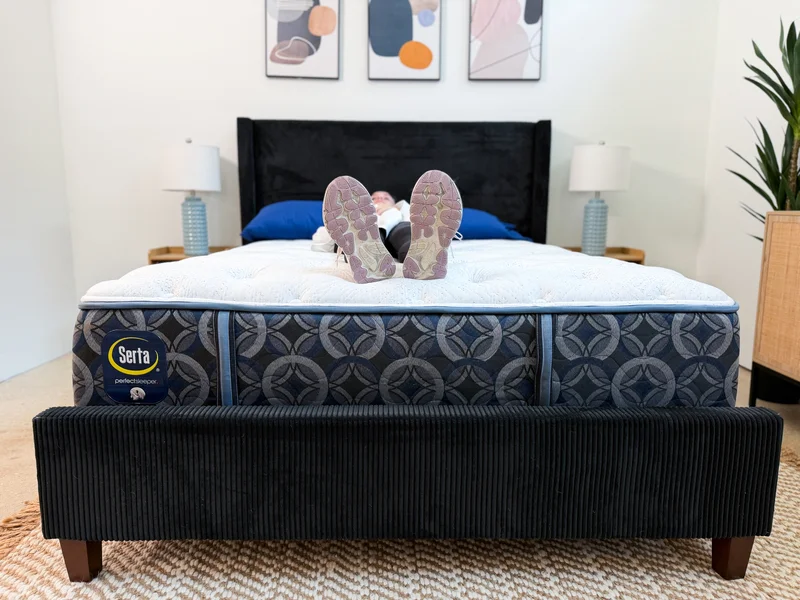A tester lying on her back on the Serta Perfect Sleeper Cascade Range Medium mattress