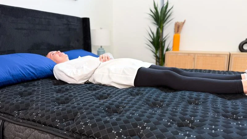 Mattress tester lying on back on Beautyrest Black.